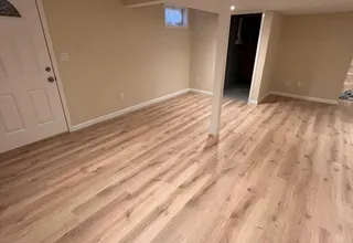 Finished basement with fresh beige walls and new light wood-look flooring