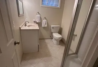 Newly painted basement bathroom with tan walls, tile floor and shower stall