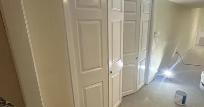 Freshly painted white six-panel closet doors and trim during an interior job